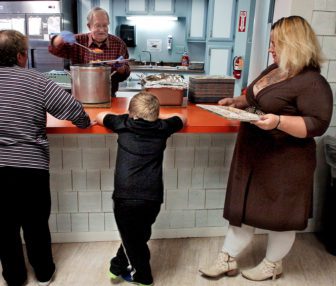 Adena Wilcox and her son, Michael, stand in line for dinner at Skowhegan’s St. Anthony’s Soup Kitchen.