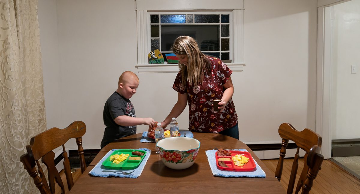 Courtney Allen divides up portions of bacon with her son Aimin after setting the table before dinner at her home in Augusta, ME on Thursday, November 15, 2018. (Photo by Yoon S. Byun)