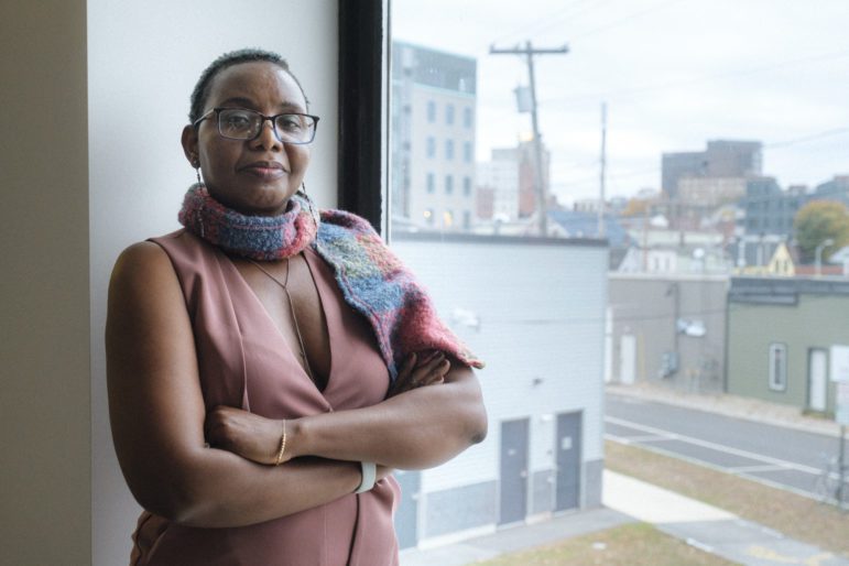 Mufalo Chitam, executive director of the Maine Immigrants’ Rights Coalition, stands in her new office space along Marginal Way in Portland. Chitam helped distribute more than $200,000 in food assistance for the state's communities of color this summer. Photo by Bailey Beltramo.