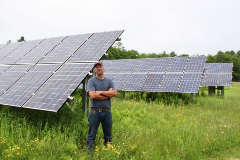 Seth Kroeck relies entirely on the energy generated by a community solar project to run Crystal Spring Farm in Brunswick. While some advocates say that local arrays like this one could reduce the need for new transmission lines if they can operate "off the grid," the state will still need additional sources of generation to achieve decarbonization by 2050. Photo by Kate Lusignan.