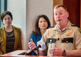 Kennebec County Sheriff Ken Mason speaks to reporters during a news conference. Behind him are Justice Michael Murphy and District Attorney Maeghan Maloney.