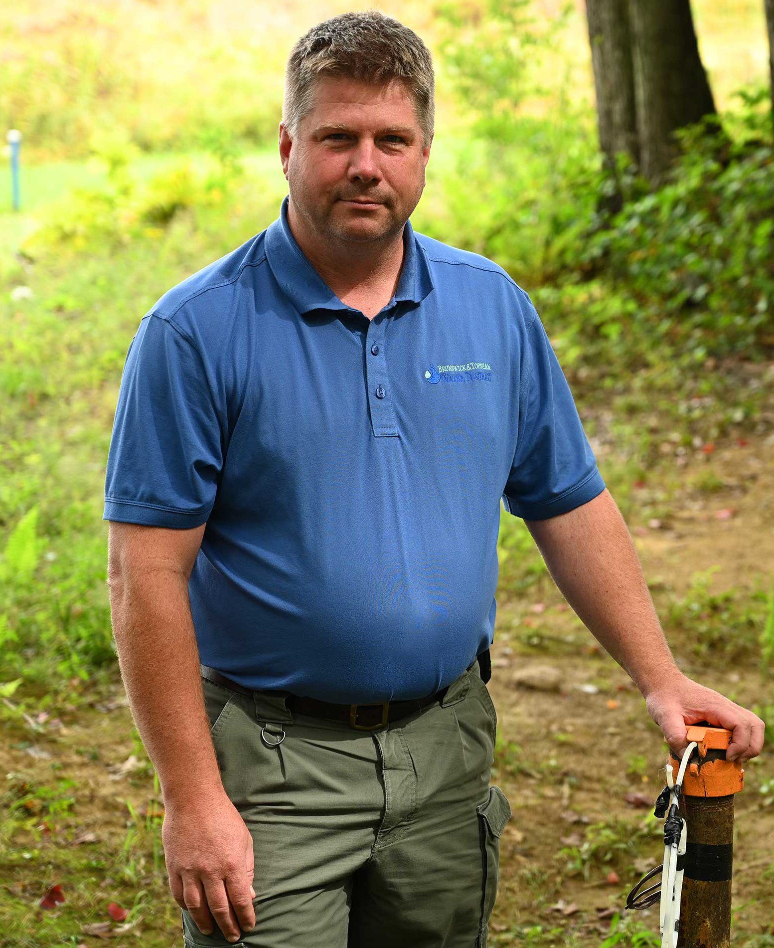 Craig Douglas stands next to a monitoring well