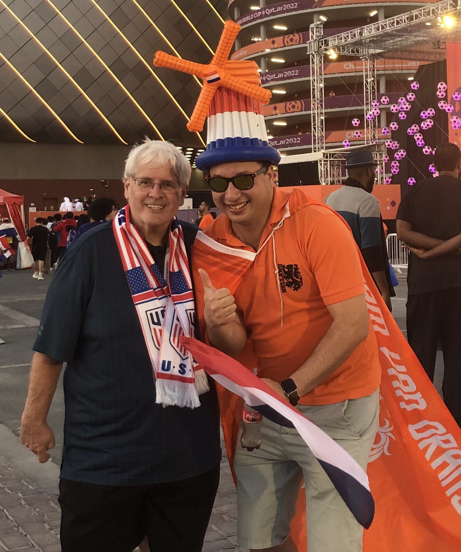 Hal and a Netherlands fan, who is dressed with an orange cape and windmill, pose for a photo outside the stadium