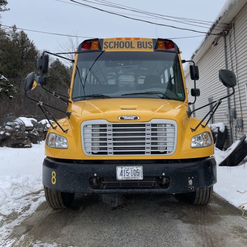 The front view of a yellow school bus. 