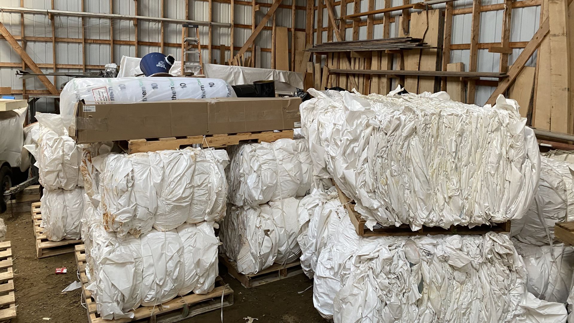 Bales of plastic boat covers in a warehouse.