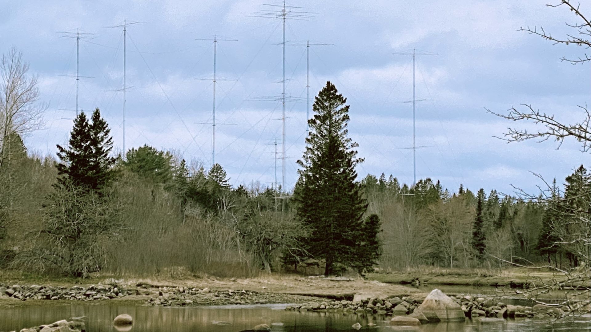 A group of antennas tower over Jonesboro's green trees in the distance. 